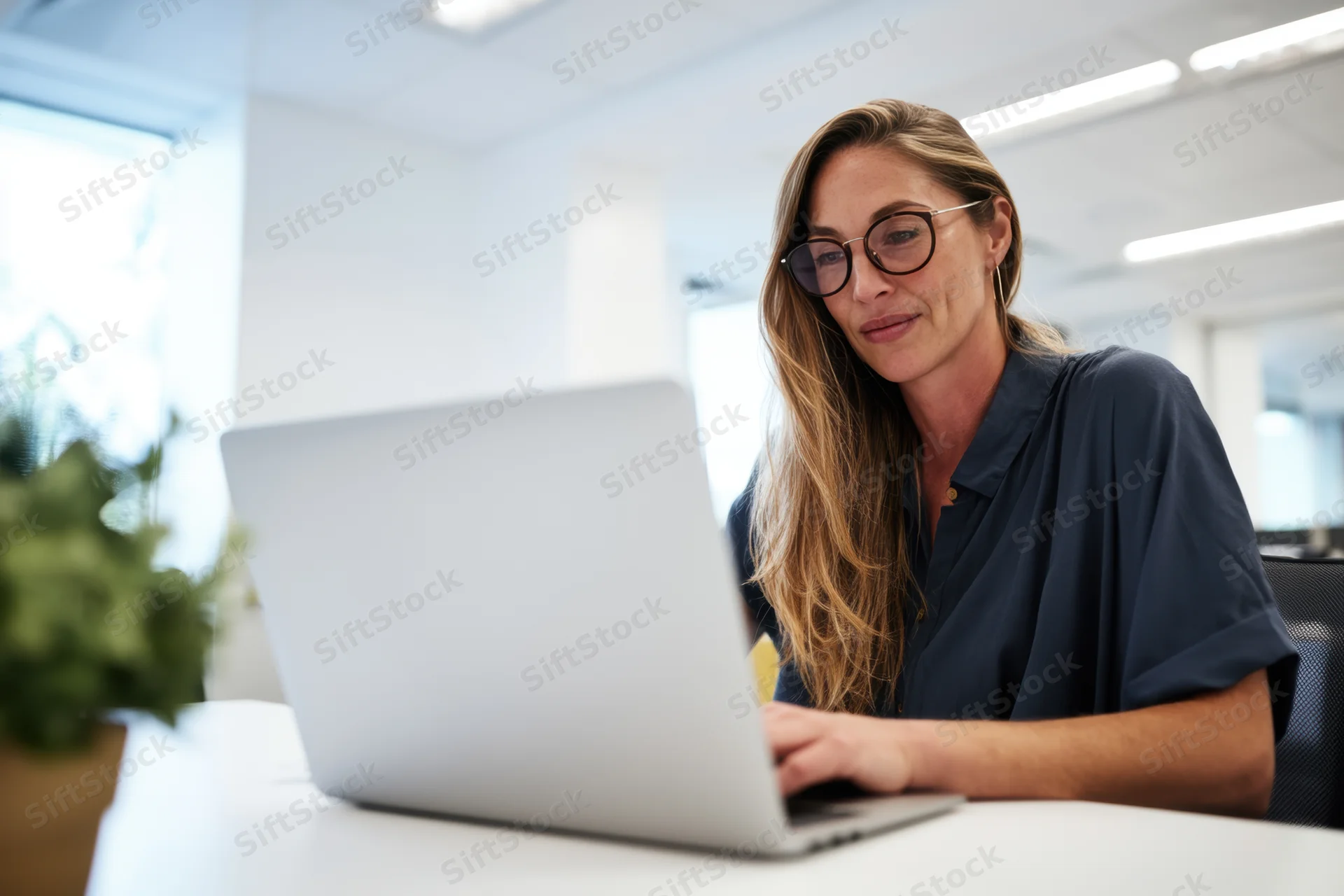 Woman working on laptop at office desk