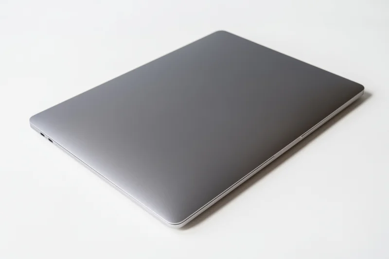 Closed sleek dark gray aluminum laptop on white surface