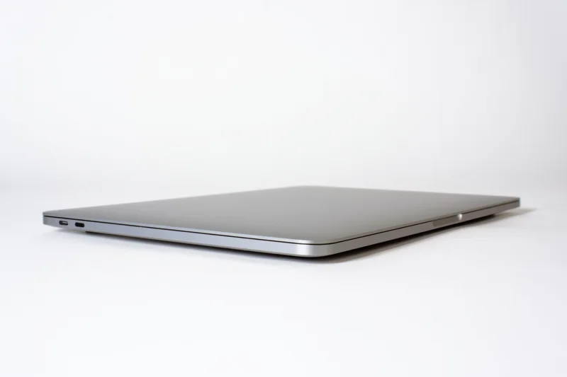 Closed sleek aluminum laptop viewed from side on white background