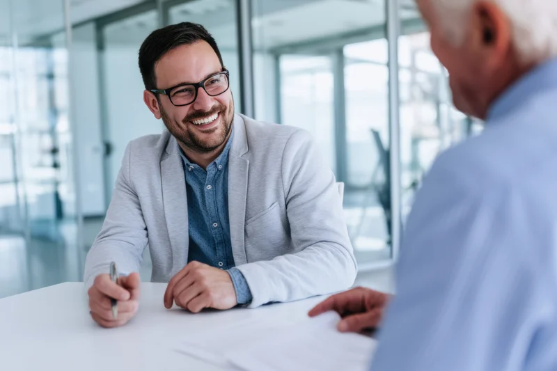 Businessman smiling during meeting at office desk with client