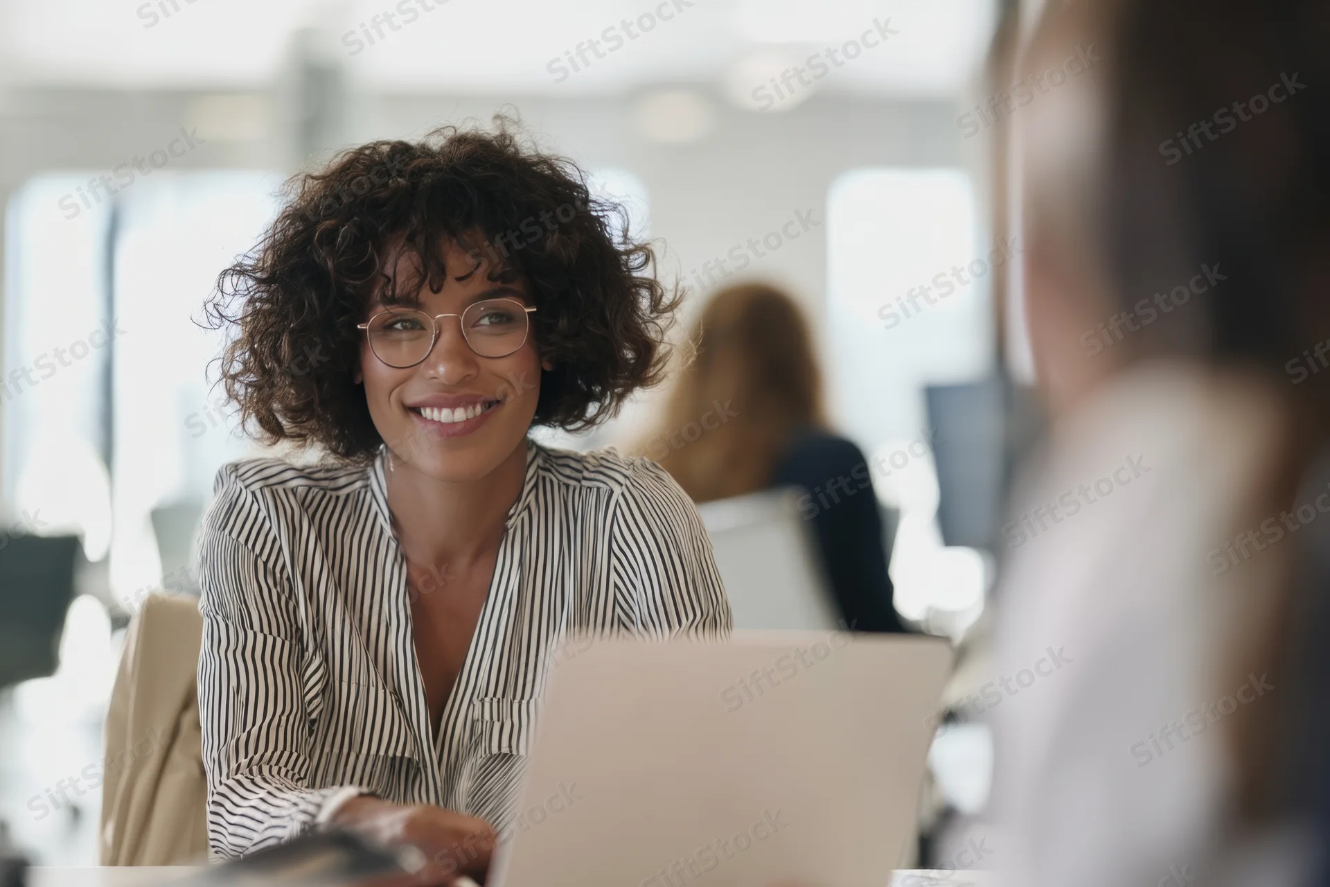 Woman smiling during a meeting at her desk in an office