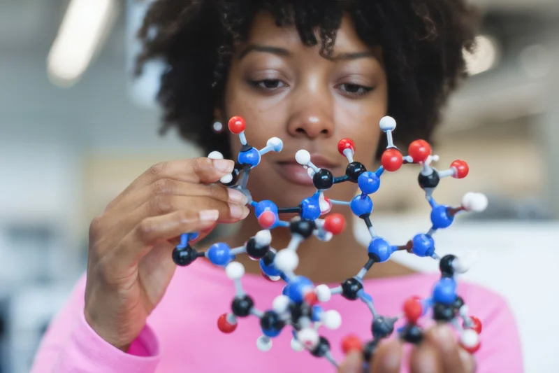 Woman holding a colorful molecular model in a laboratory setting