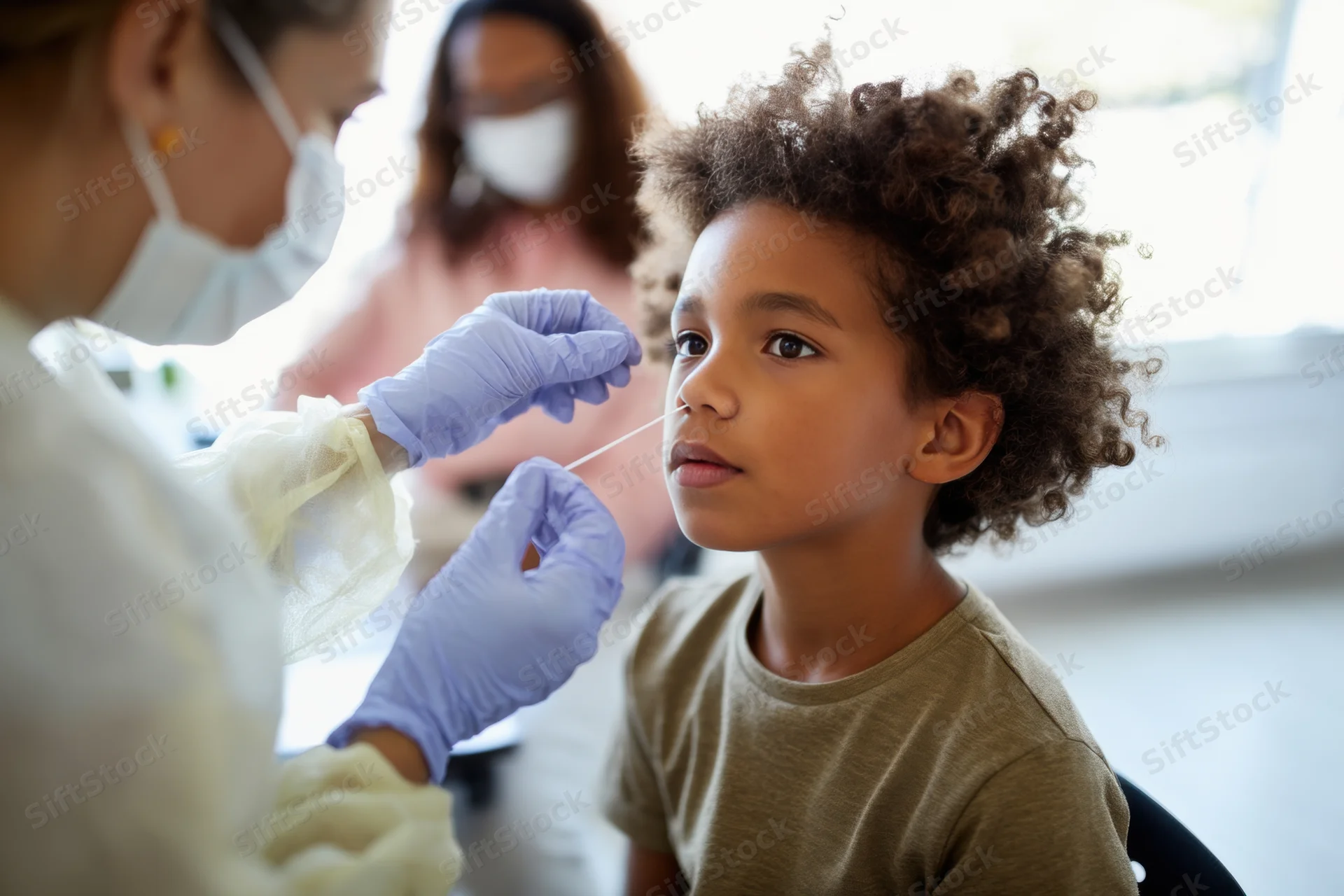Young boy receiving nasal swab test from healthcare professional in clinic