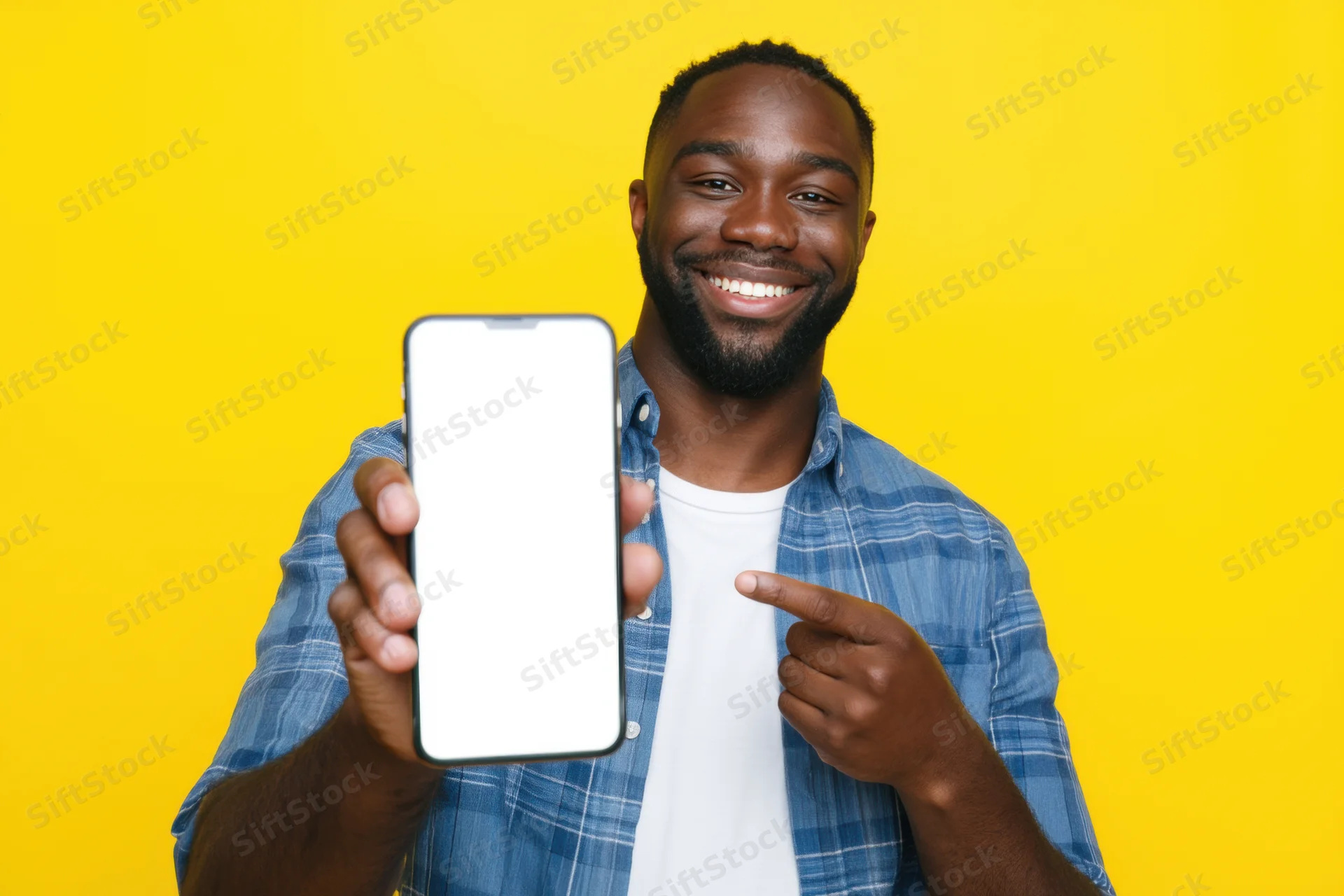 Smiling man pointing at smartphone screen against yellow background
