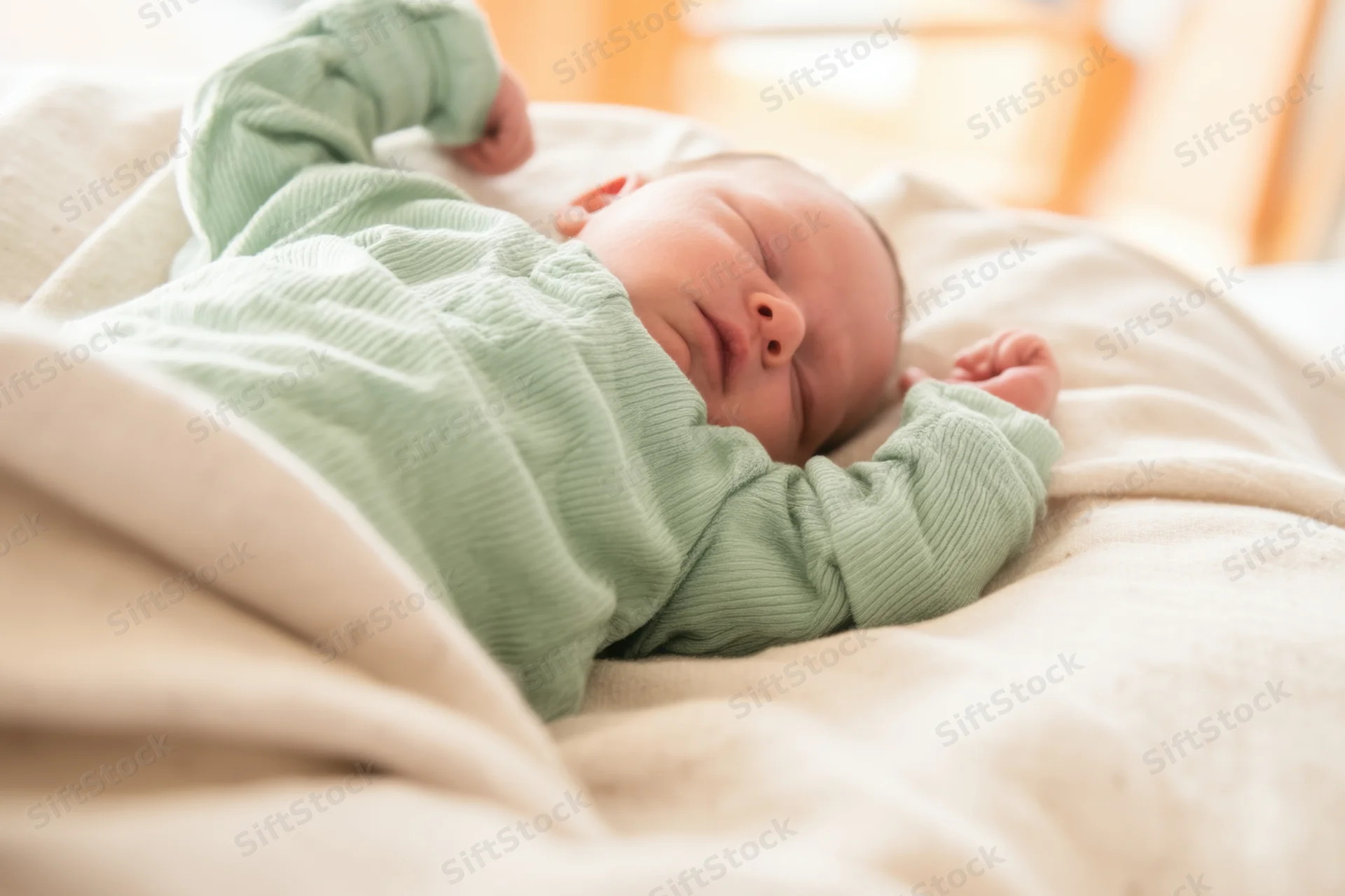 Newborn baby sleeping peacefully on a soft blanket in a crib