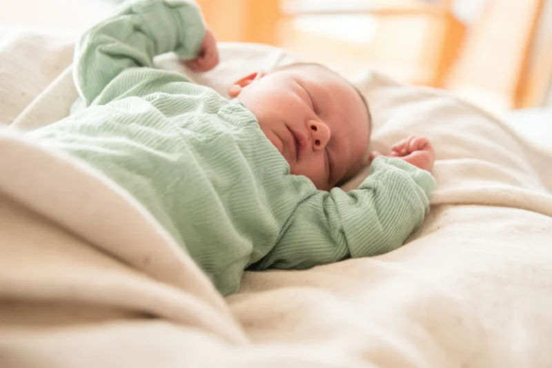 Newborn baby sleeping peacefully on a soft blanket in a crib