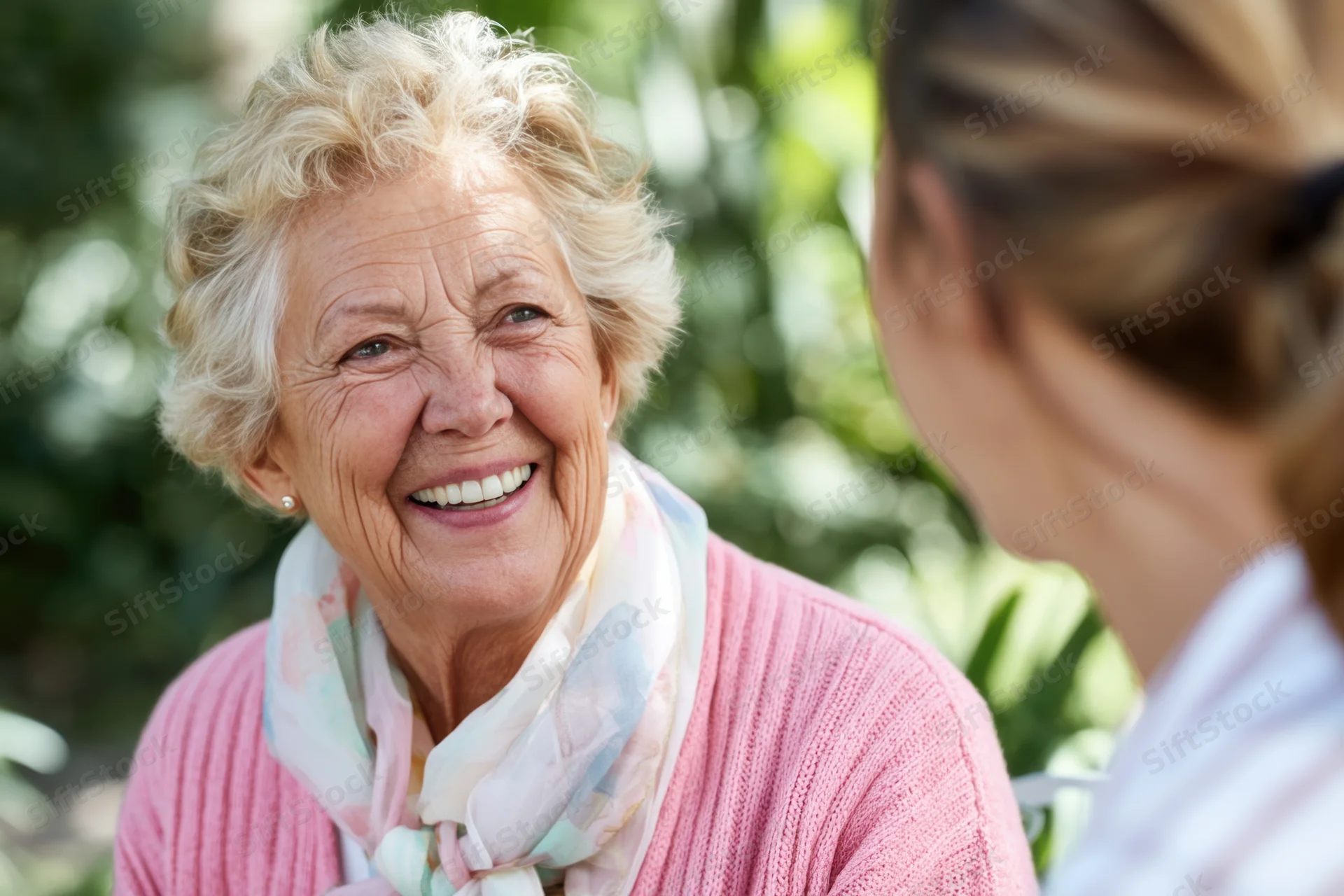 Elderly woman smiling warmly during a conversation in a garden setting