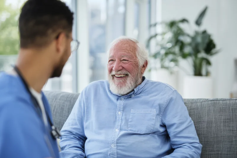 Elderly man smiling during consultation with doctor in clinic office
