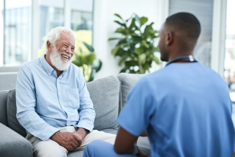 Elderly man smiling during consultation with healthcare provider in clinic office
