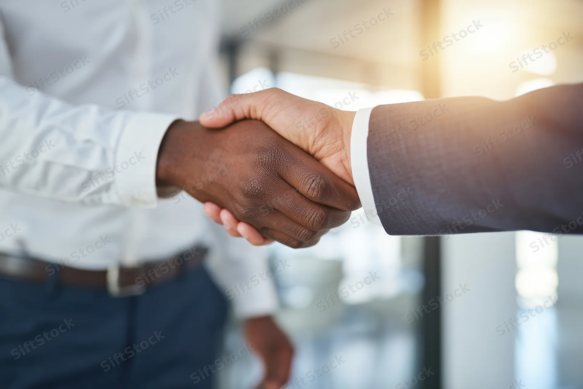 Two professionals shaking hands in a modern office