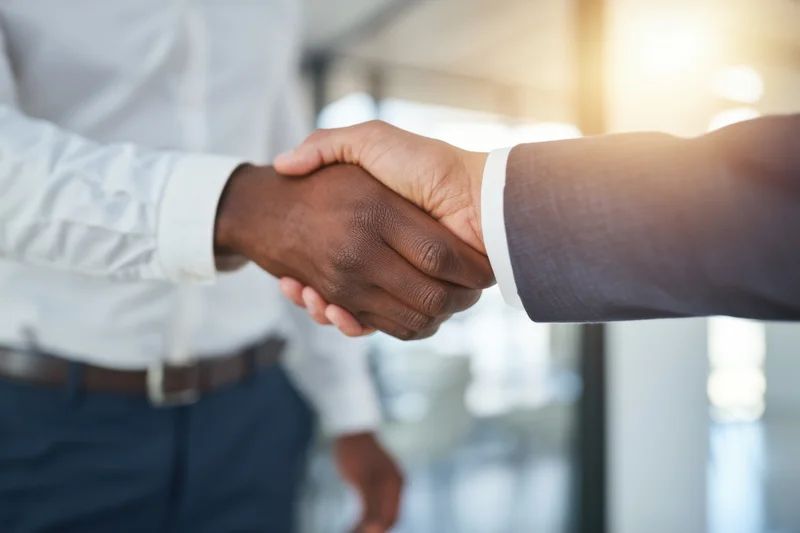 Two professionals shaking hands in a modern office