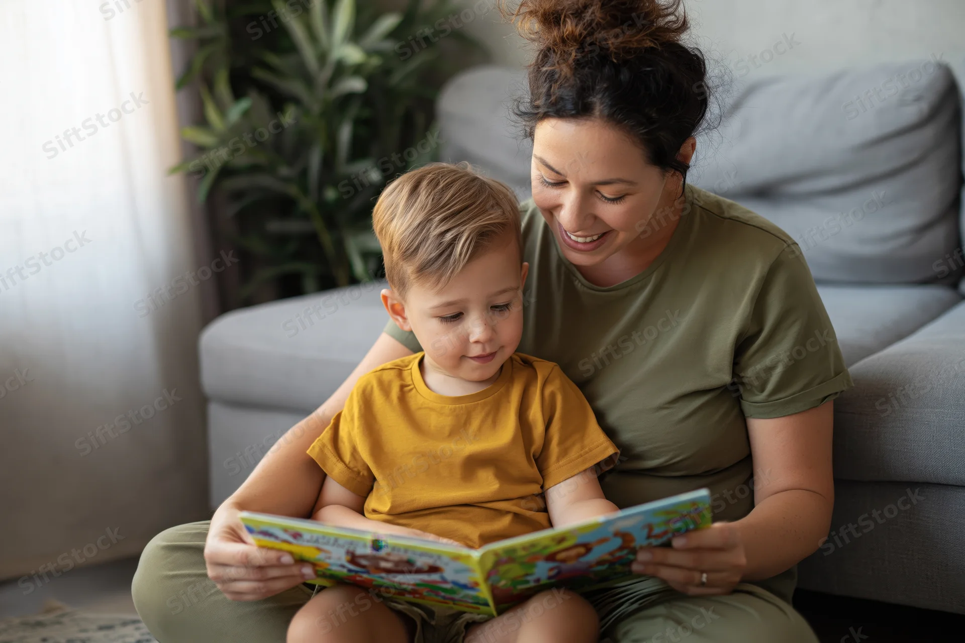 Mother and toddler reading a book together on the floor in a living room