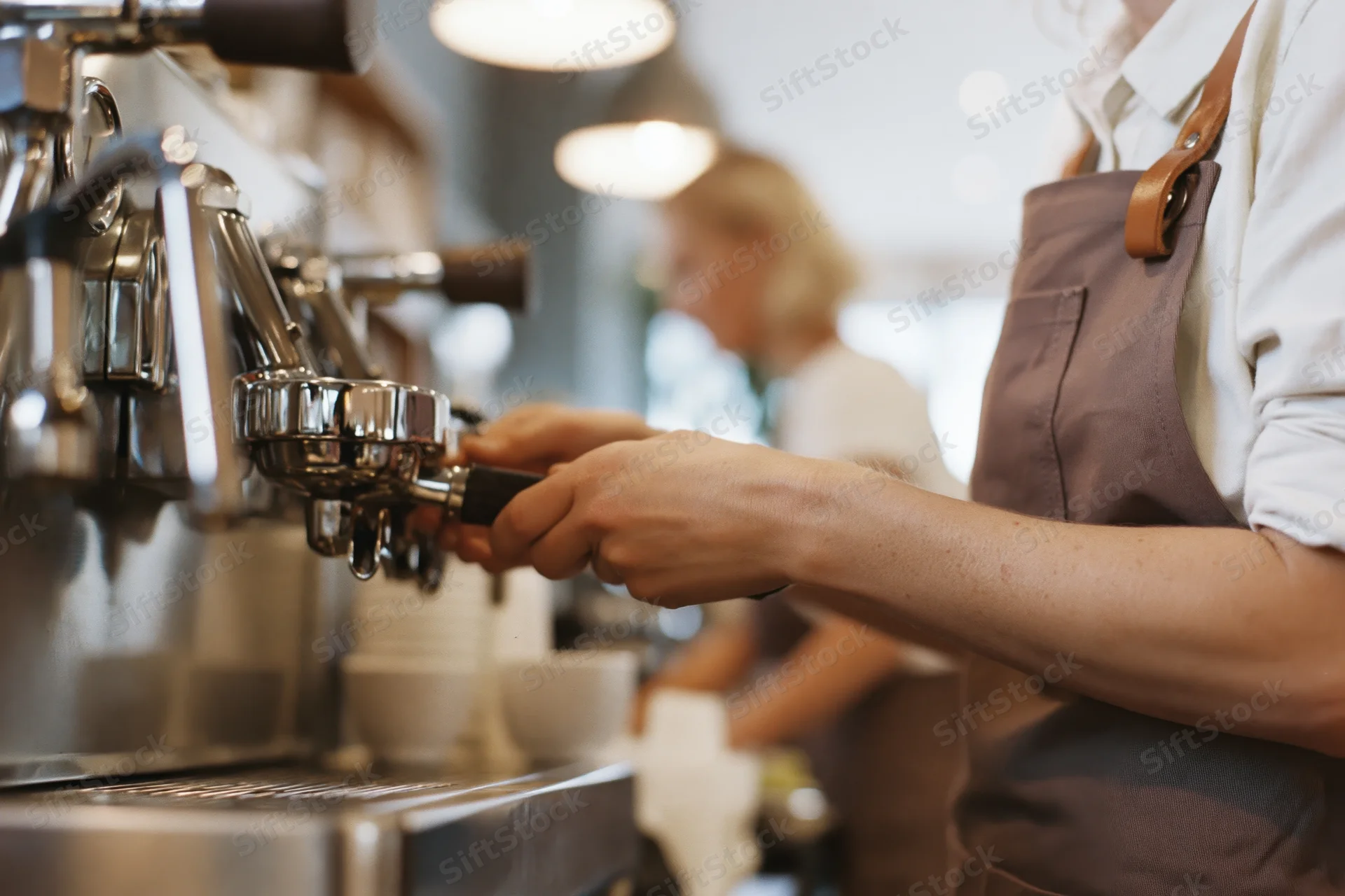 Barista operating espresso machine in a cafe