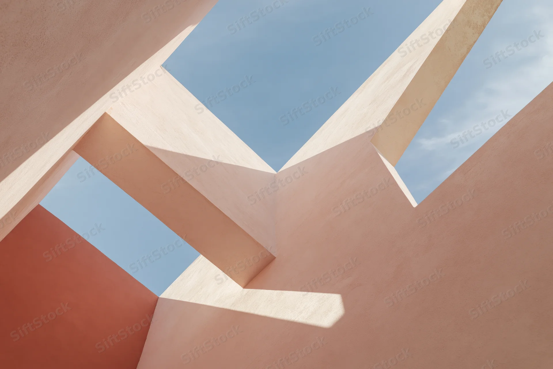 Abstract architectural structure viewed upward with geometric forms and sky visible through openings