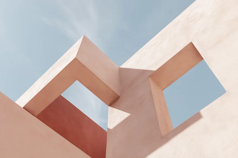 Abstract architectural structure with geometric cutouts framing the sky