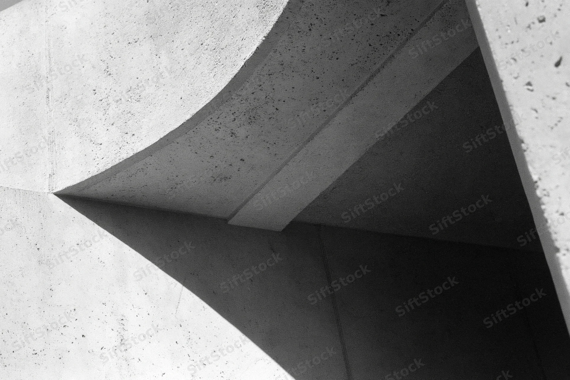 Abstract concrete architectural detail with intersecting angular forms and shadows