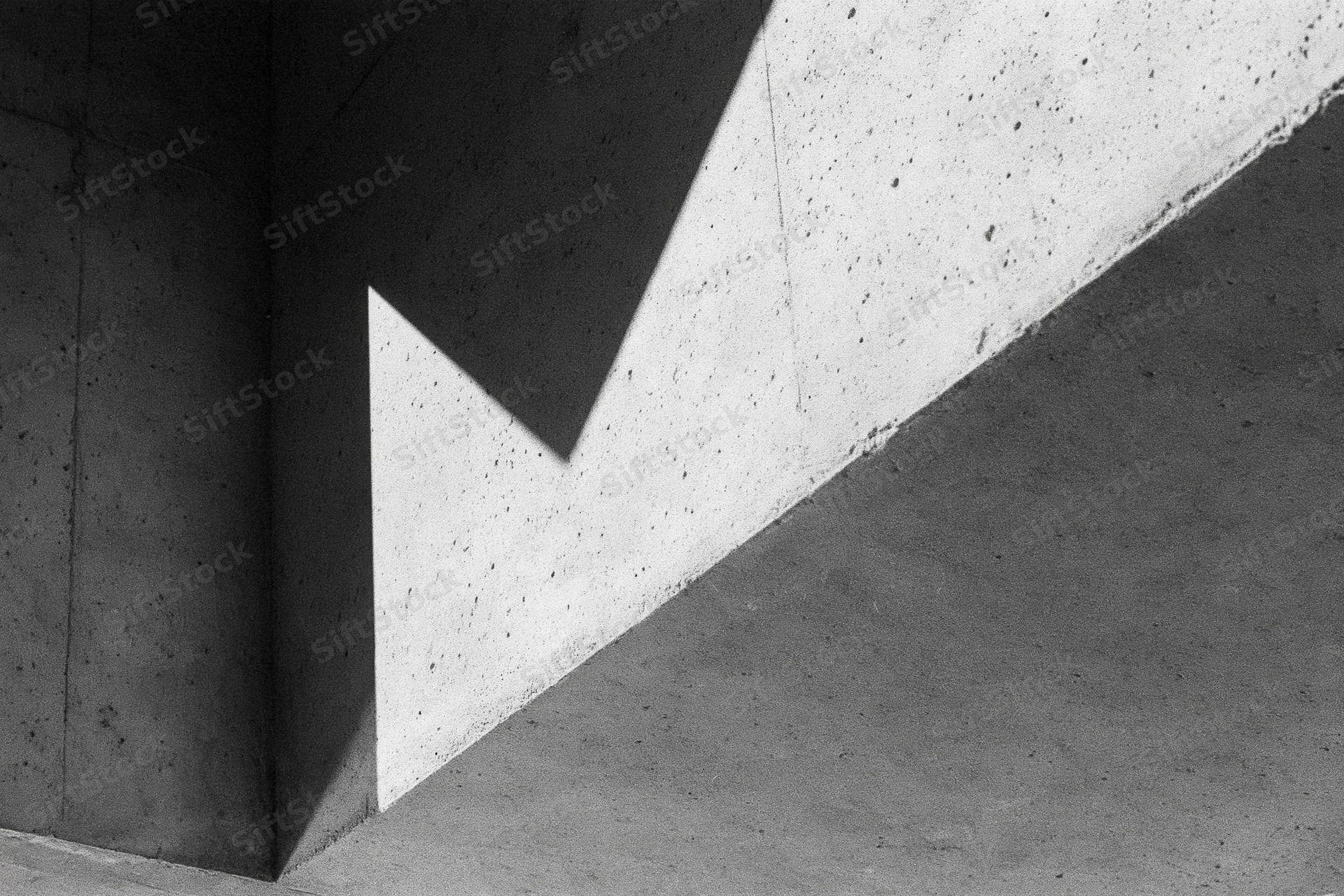Angular concrete architectural detail with intersecting shadows and light patterns