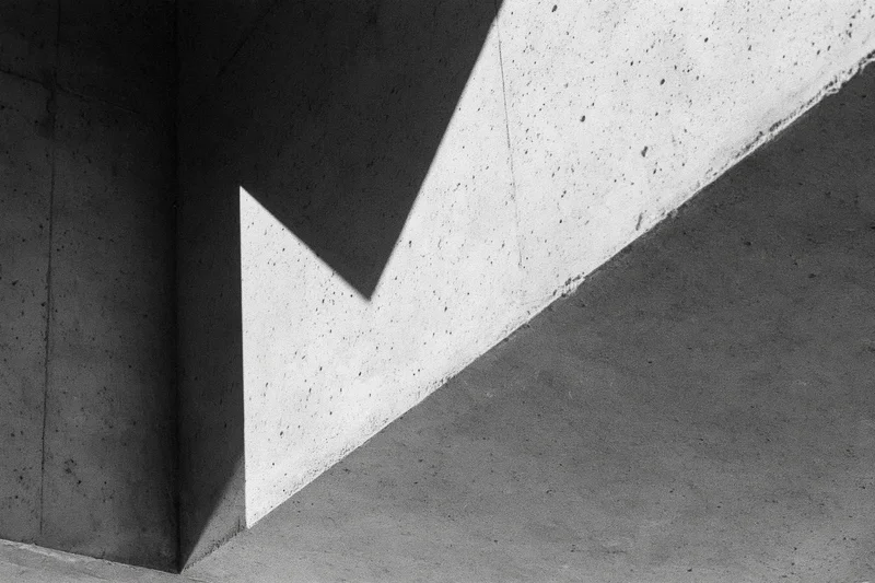 Angular concrete architectural detail with intersecting shadows and light patterns