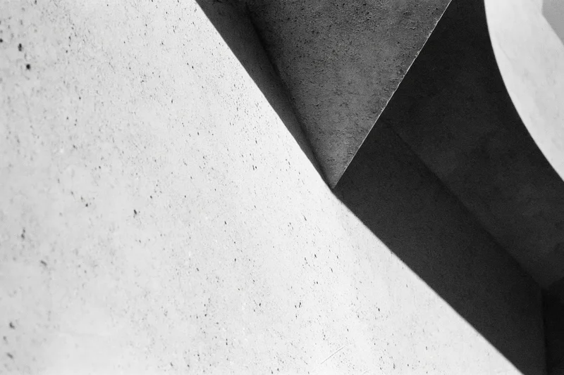 Abstract concrete architectural detail with angular intersecting forms and strong shadows