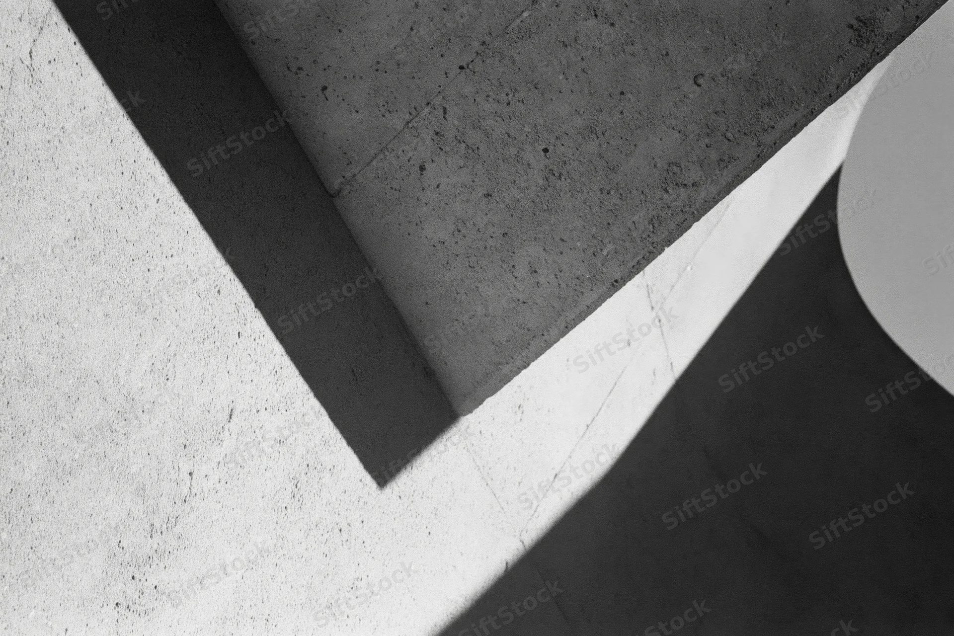 Angular concrete architectural detail with intersecting shadows and geometric forms