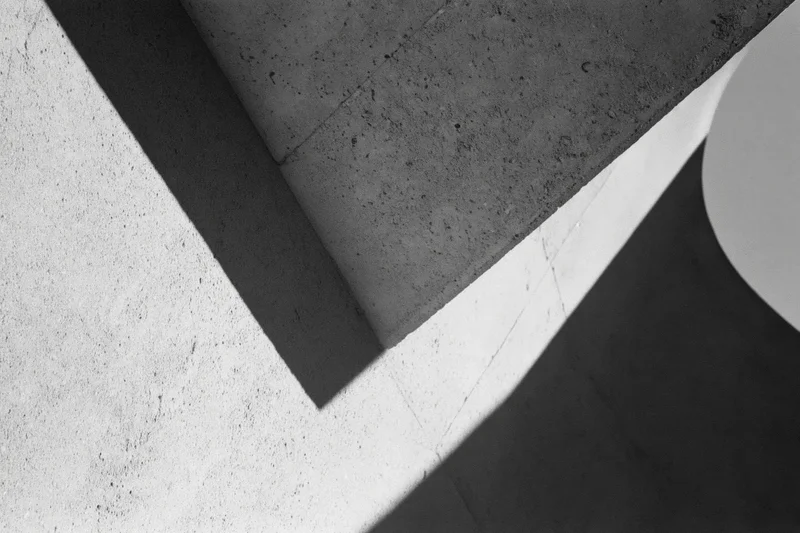 Angular concrete architectural detail with intersecting shadows and geometric forms