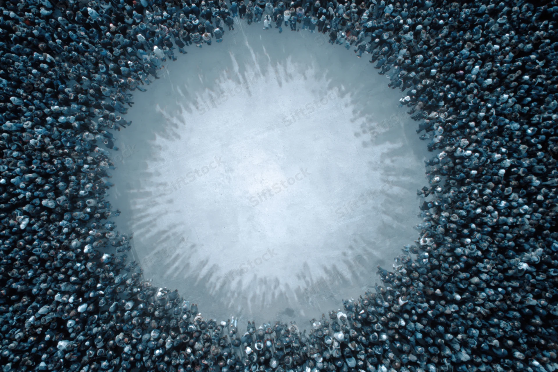 Aerial view of a large crowd forming a circular shape around an open central space