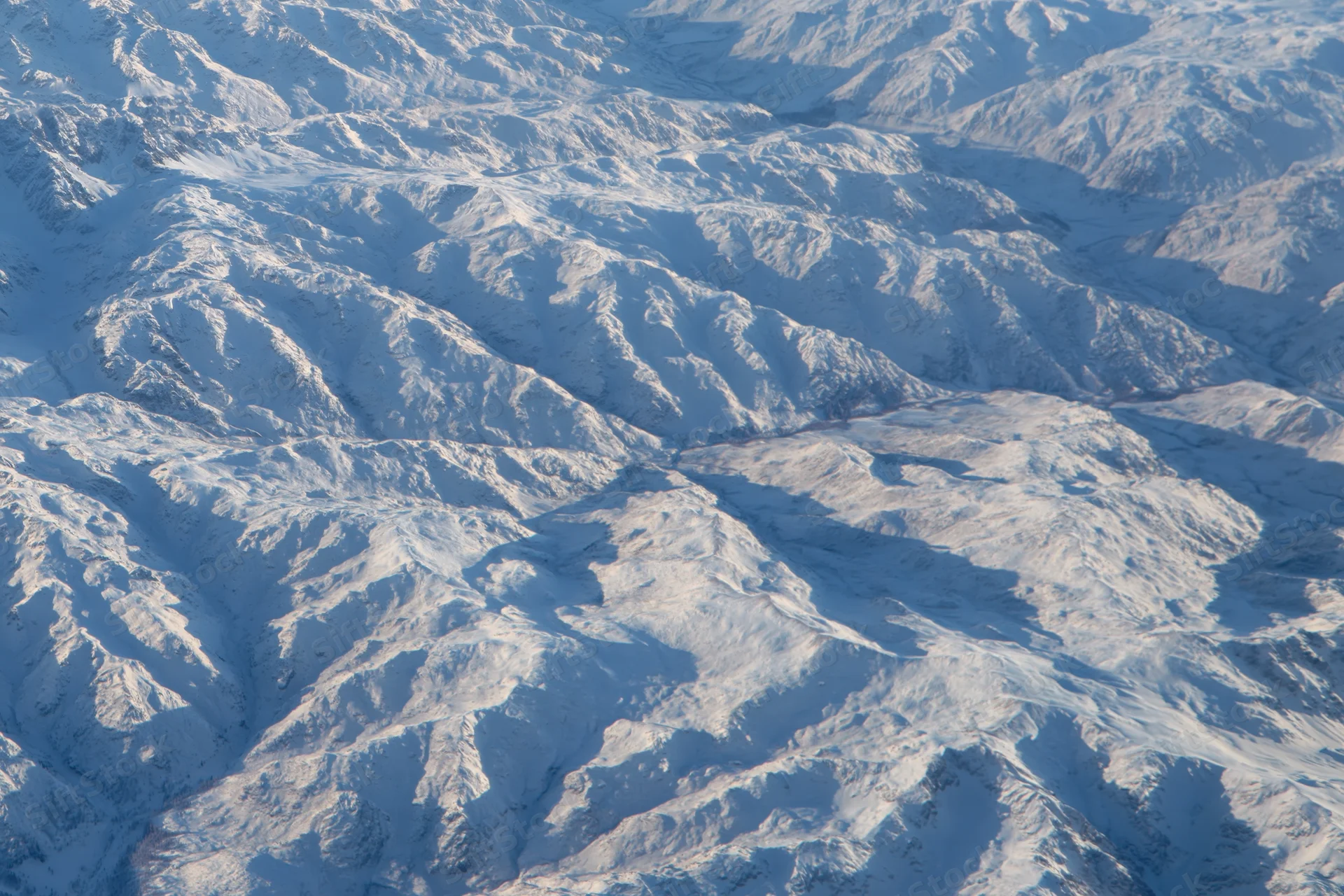 Aerial view of snow-covered mountain ridges and valleys
