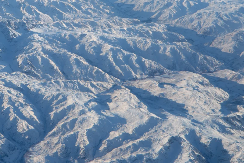 Aerial view of snow-covered mountain ridges and valleys