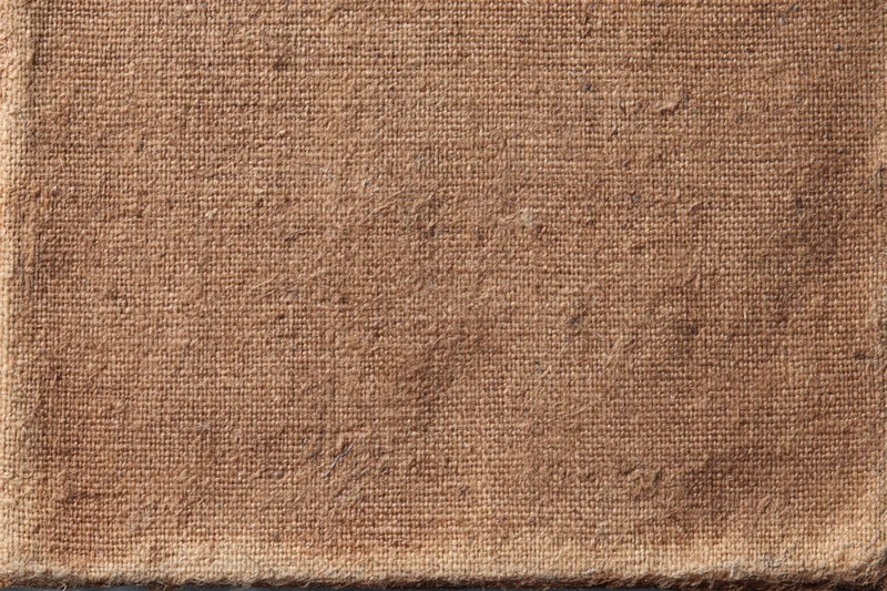 Closeup of worn brown canvas fabric with coarse weave and natural texture