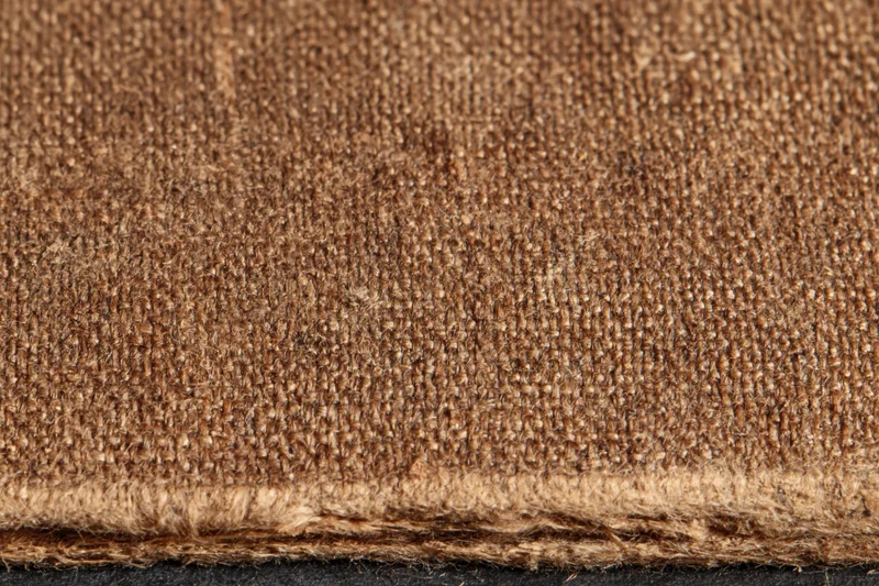 Closeup of worn brown canvas fabric texture with frayed edge