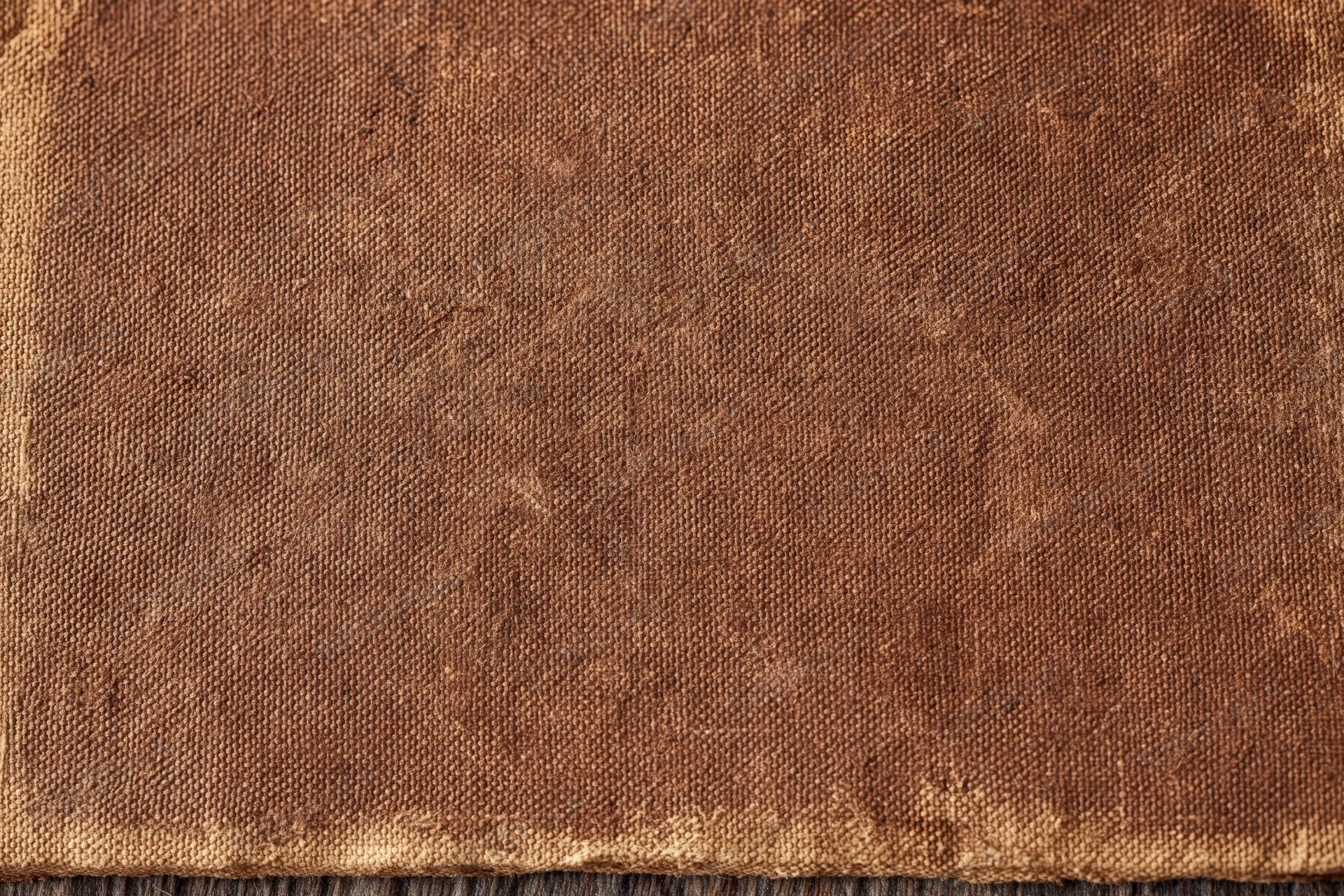 Close-up of aged brown canvas fabric with visible weave and wear marks