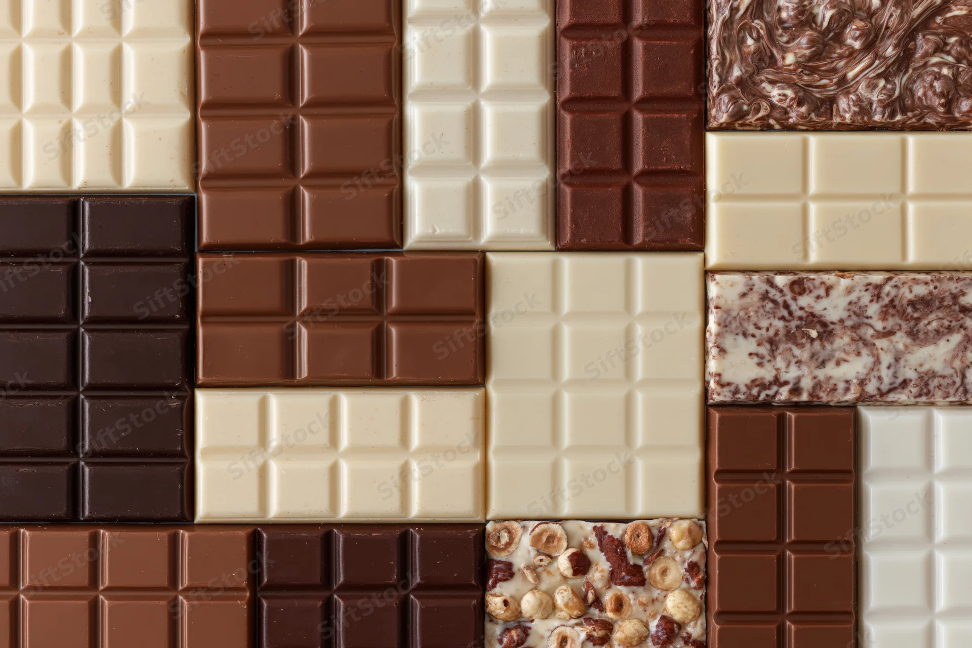 Assorted chocolate bars arranged in a grid pattern viewed from above