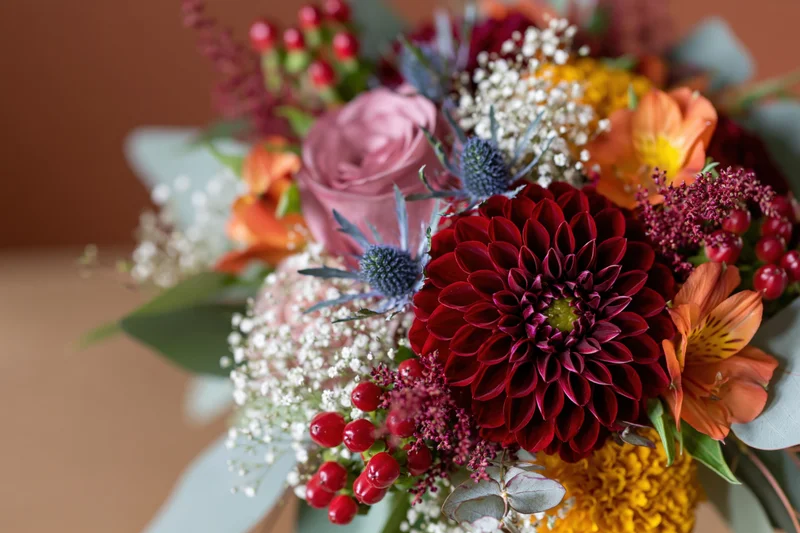 Autumn wedding bouquet with burgundy dahlias, roses, alstroemeria, and eucalyptus foliage