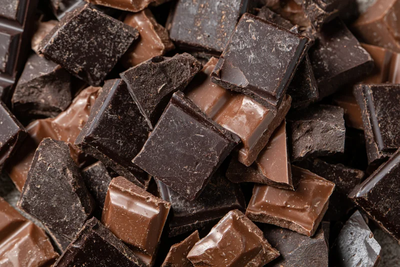 Broken chocolate chunks piled loosely filling the frame