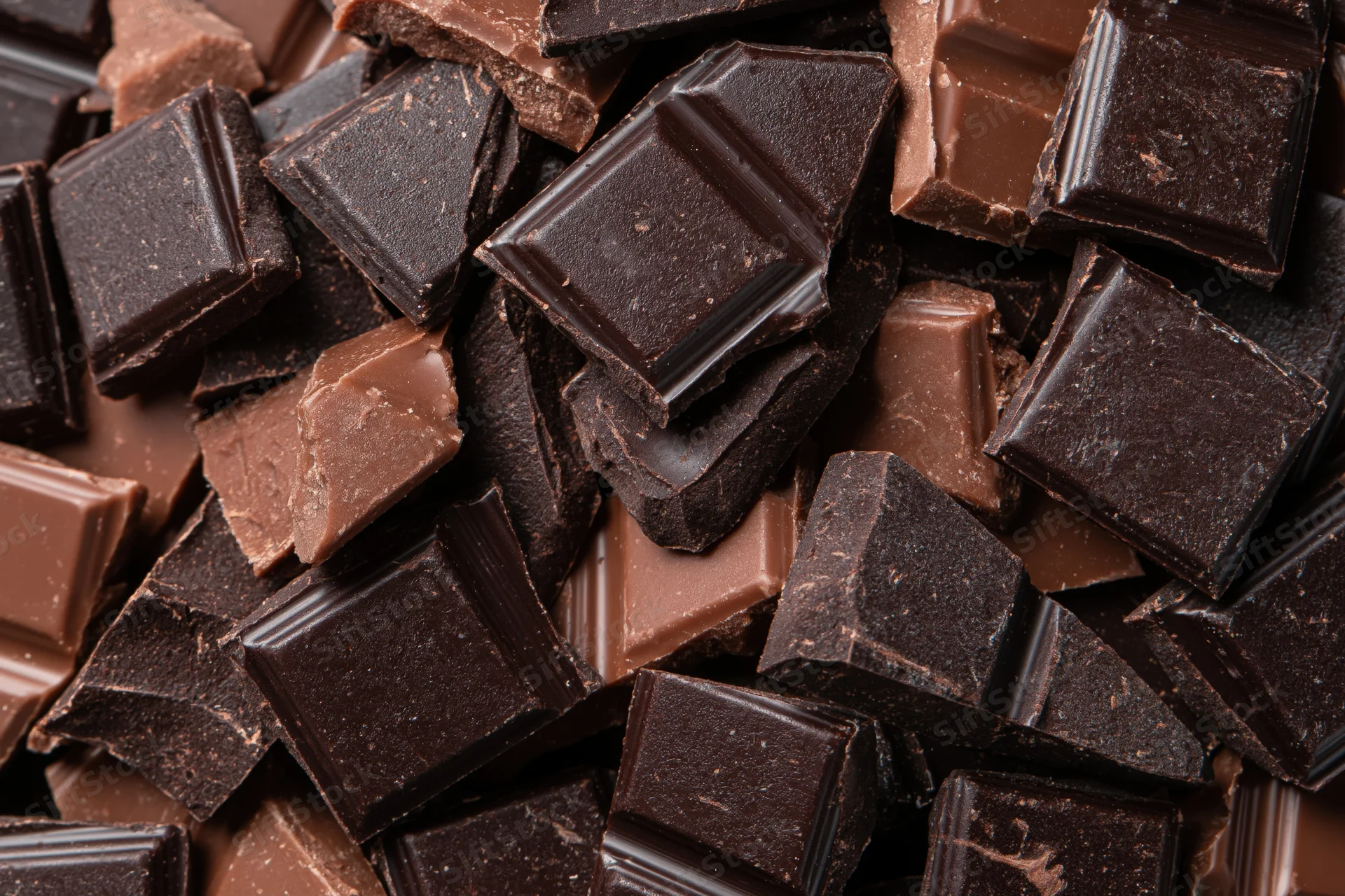 Broken chocolate pieces piled loosely filling the frame