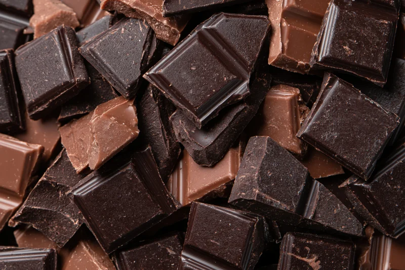 Broken chocolate pieces piled loosely filling the frame