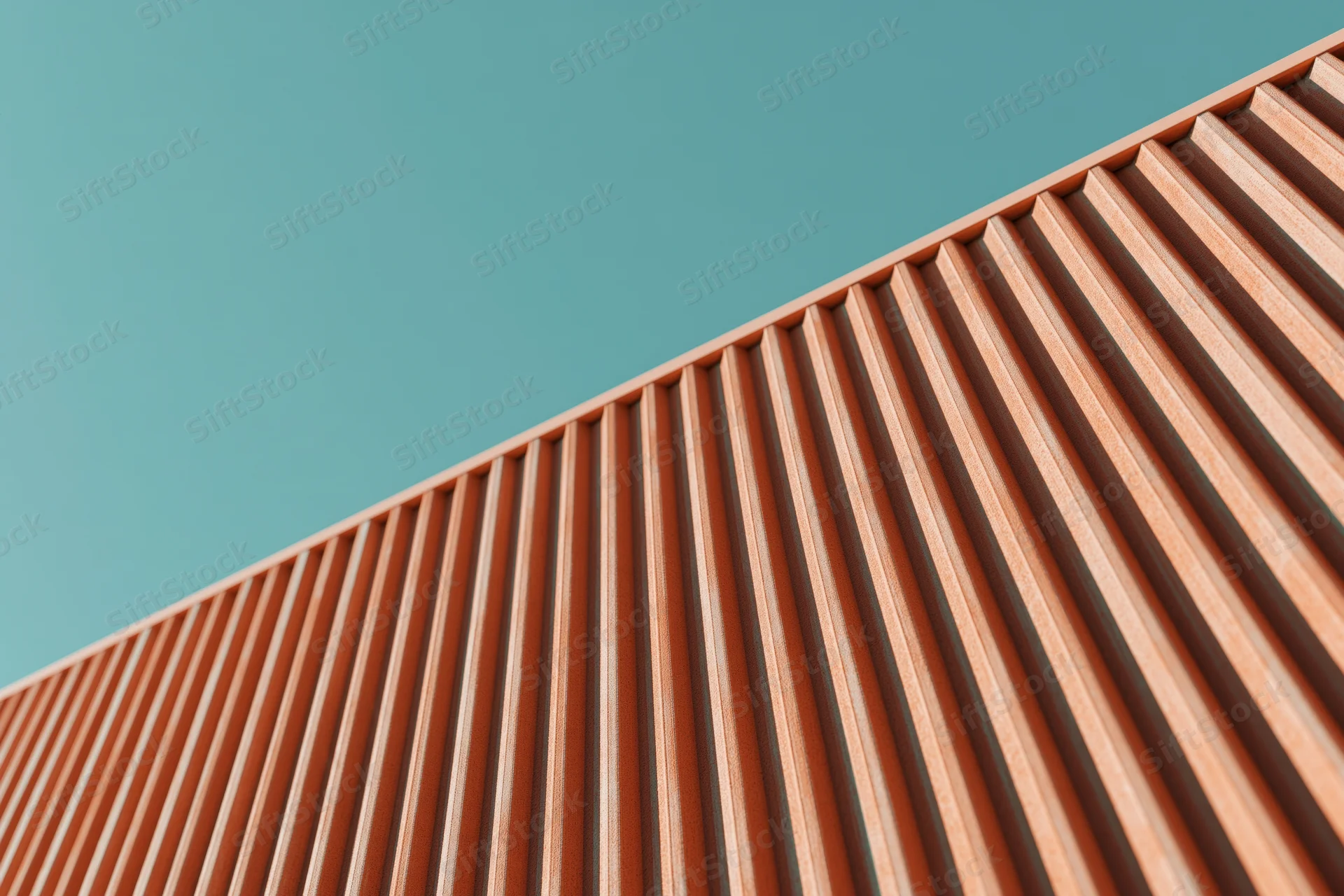 Close-up of modern building exterior cladding with corrugated panels against teal sky