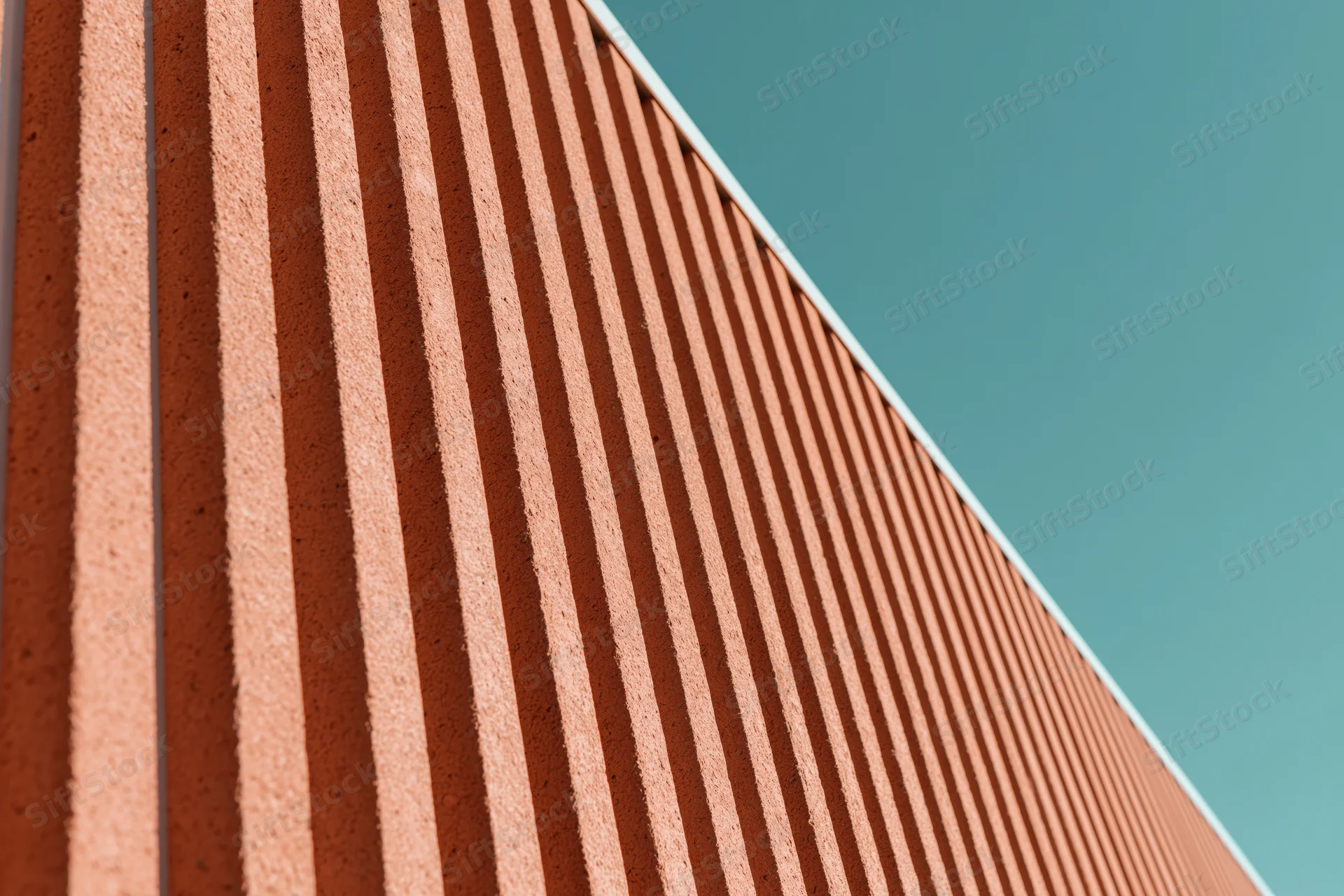 Close-up of modern building exterior cladding with corrugated panels under daylight sky