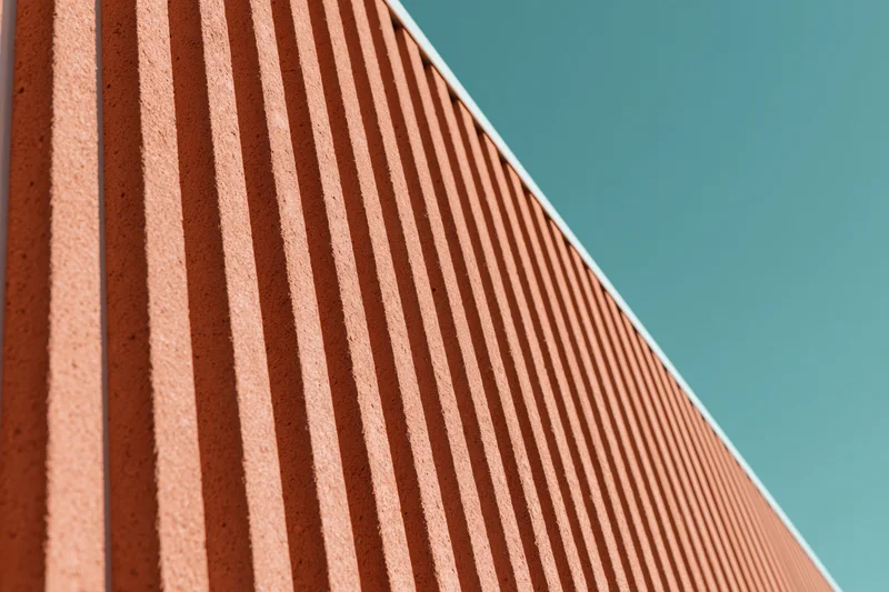 Close-up of modern building exterior cladding with corrugated panels under daylight sky