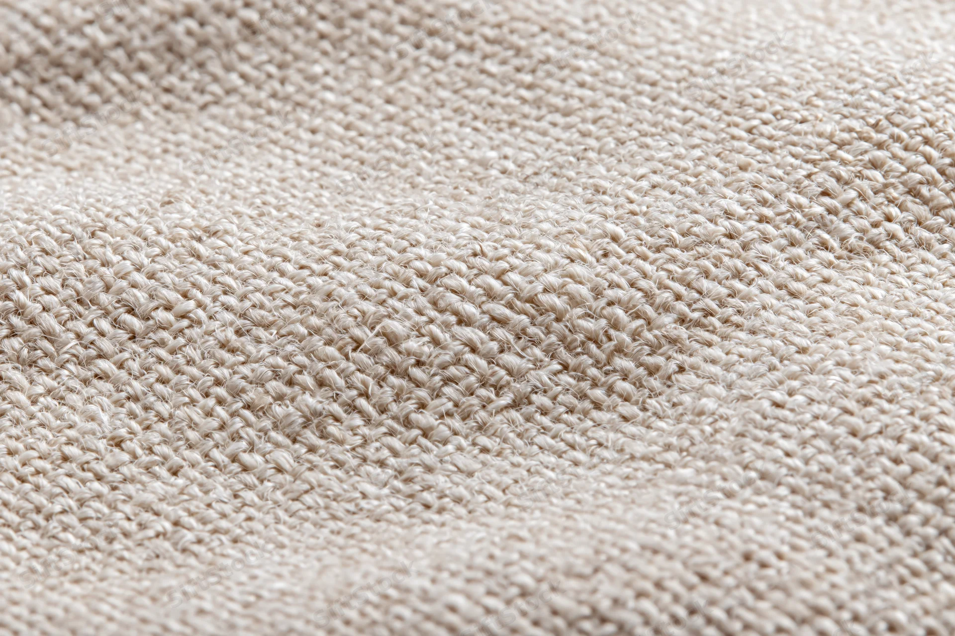 Close-up of natural linen fabric with visible weave pattern filling the frame
