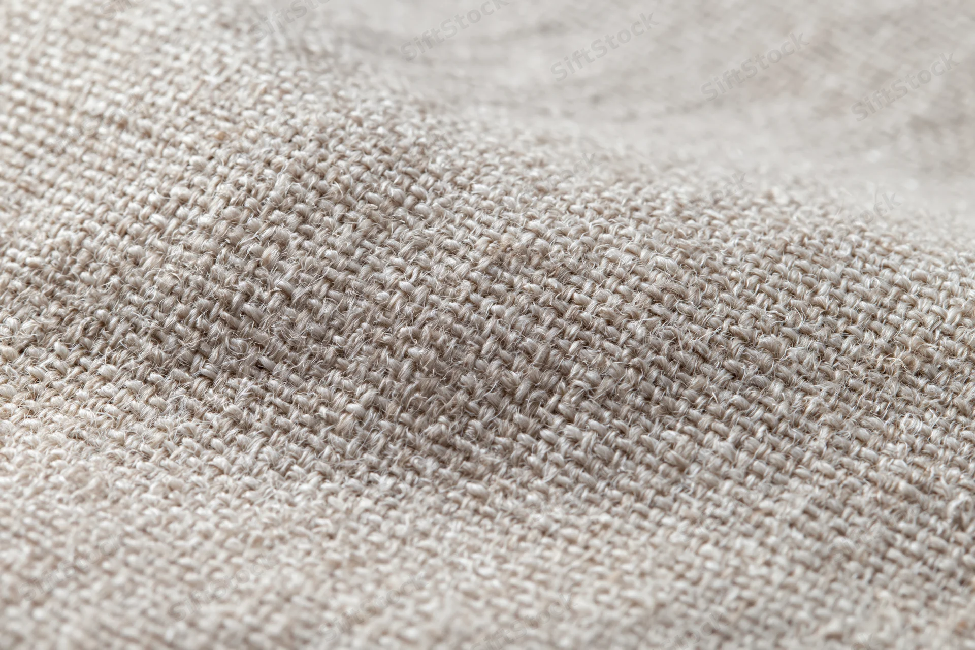 Close-up of natural linen fabric with visible weave and texture filling the frame