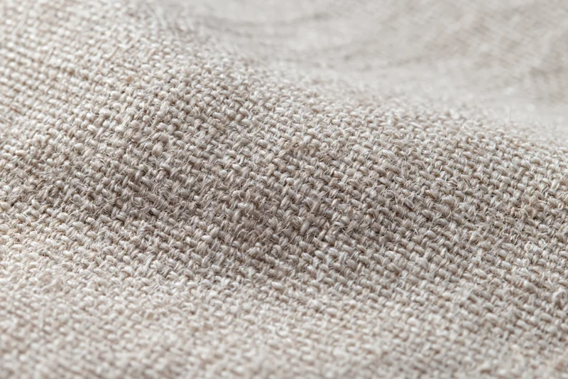 Close-up of natural linen fabric with visible weave and texture filling the frame