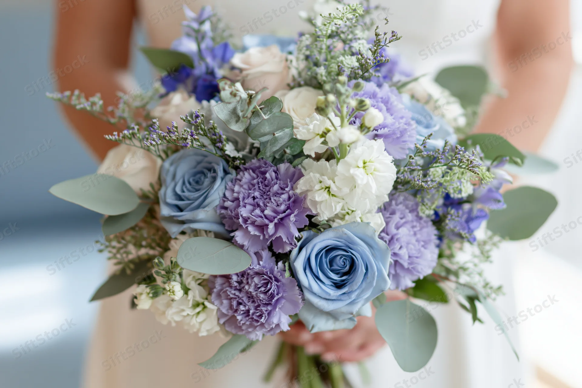 Bride holding a lush bridal bouquet of blue roses, purple carnations, and eucalyptus leaves