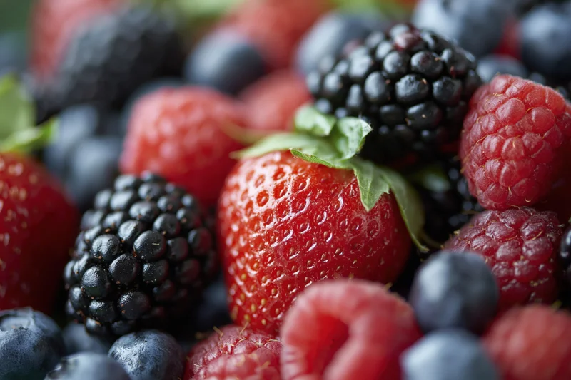 Close-up of a pile of mixed berries including strawberries, blackberries, raspberries and blueberries