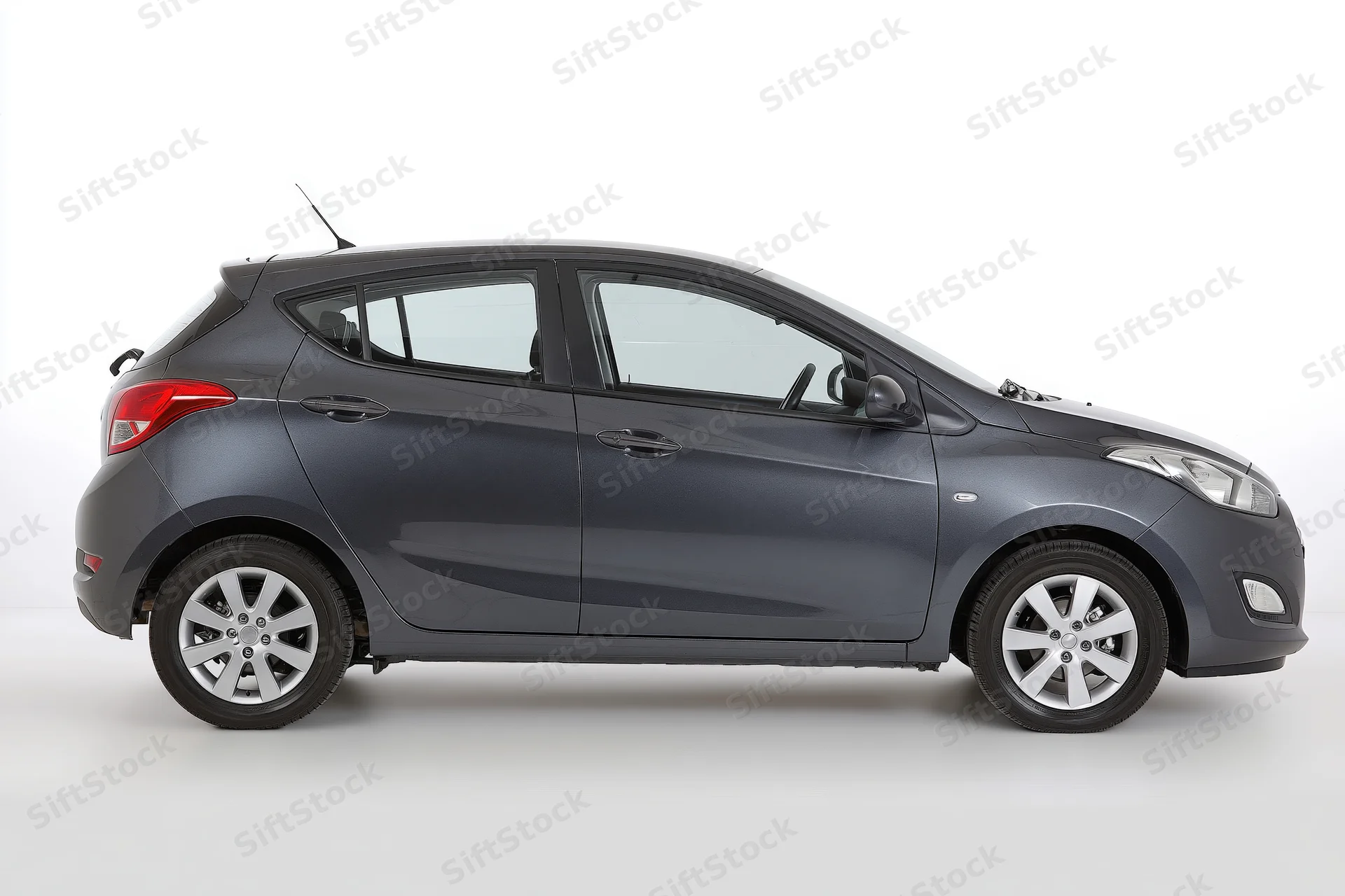 Dark grey compact hatchback in side profile against white background