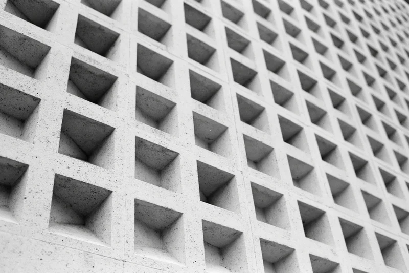 Closeup of a modernist concrete building facade with a geometric grid pattern