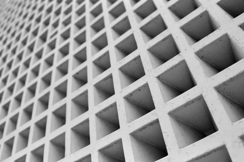 Closeup of a modernist concrete building facade with a geometric grid pattern