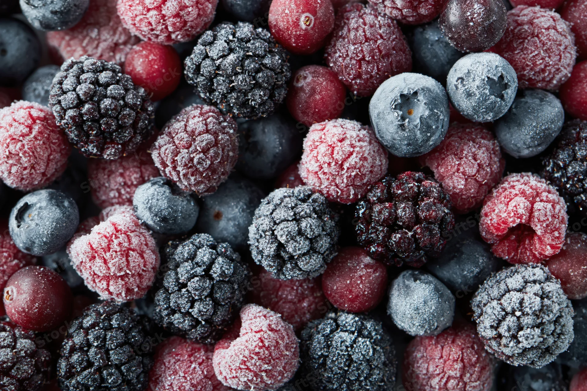 Frozen mixed berries covered in frost filling the frame