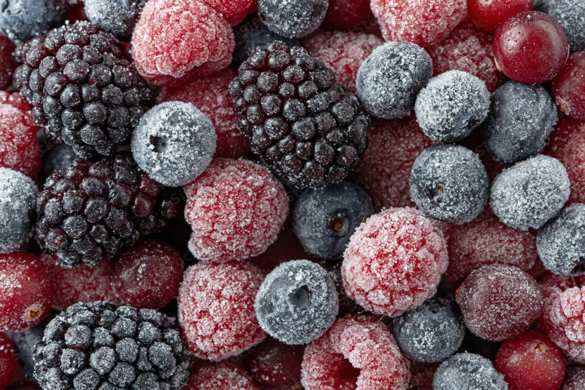Frozen mixed berries covered in frost filling the frame