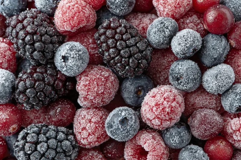 Frozen mixed berries covered in frost filling the frame